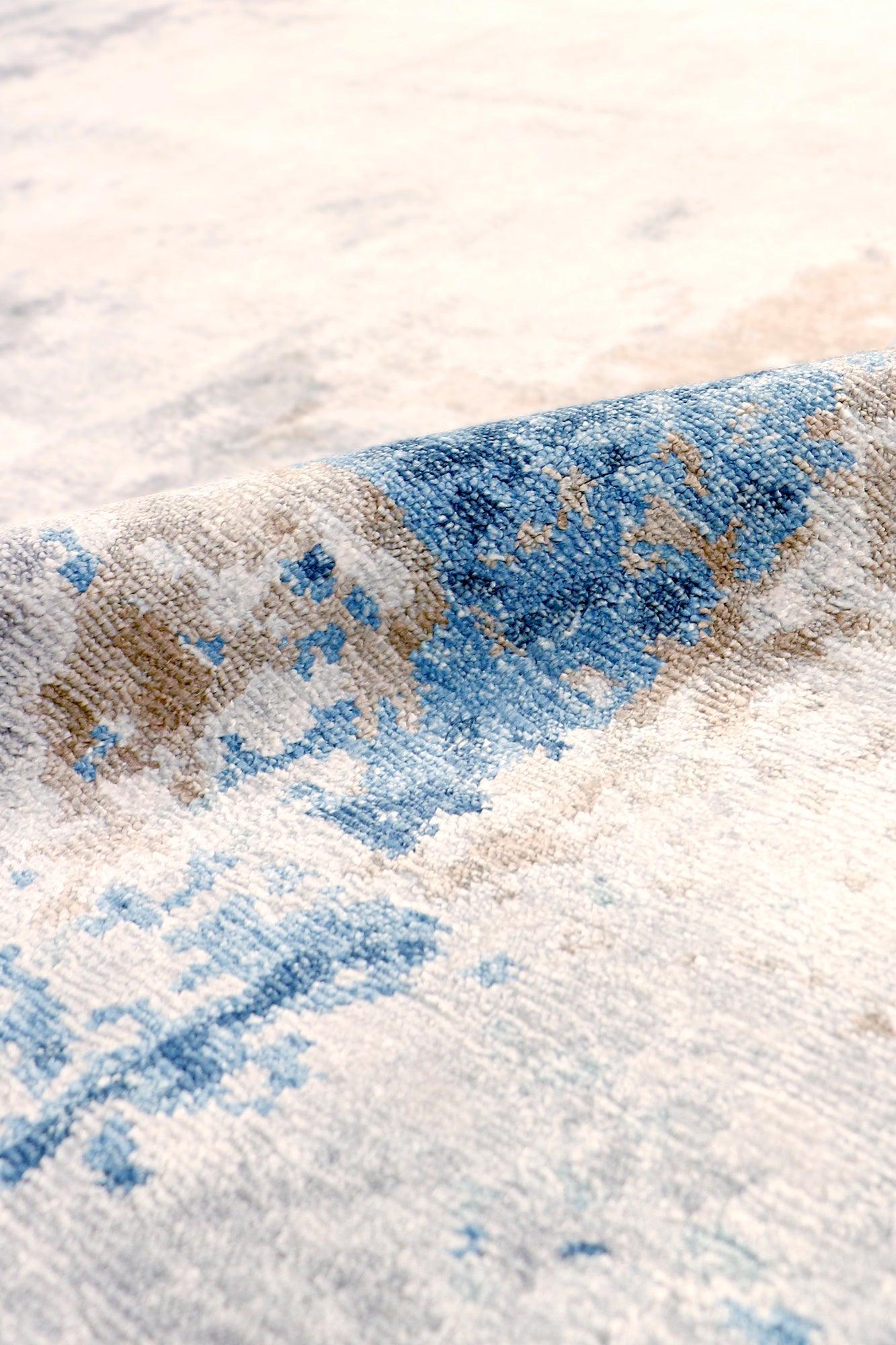Close-up of a textured rug with blue and brown patterns on a light background