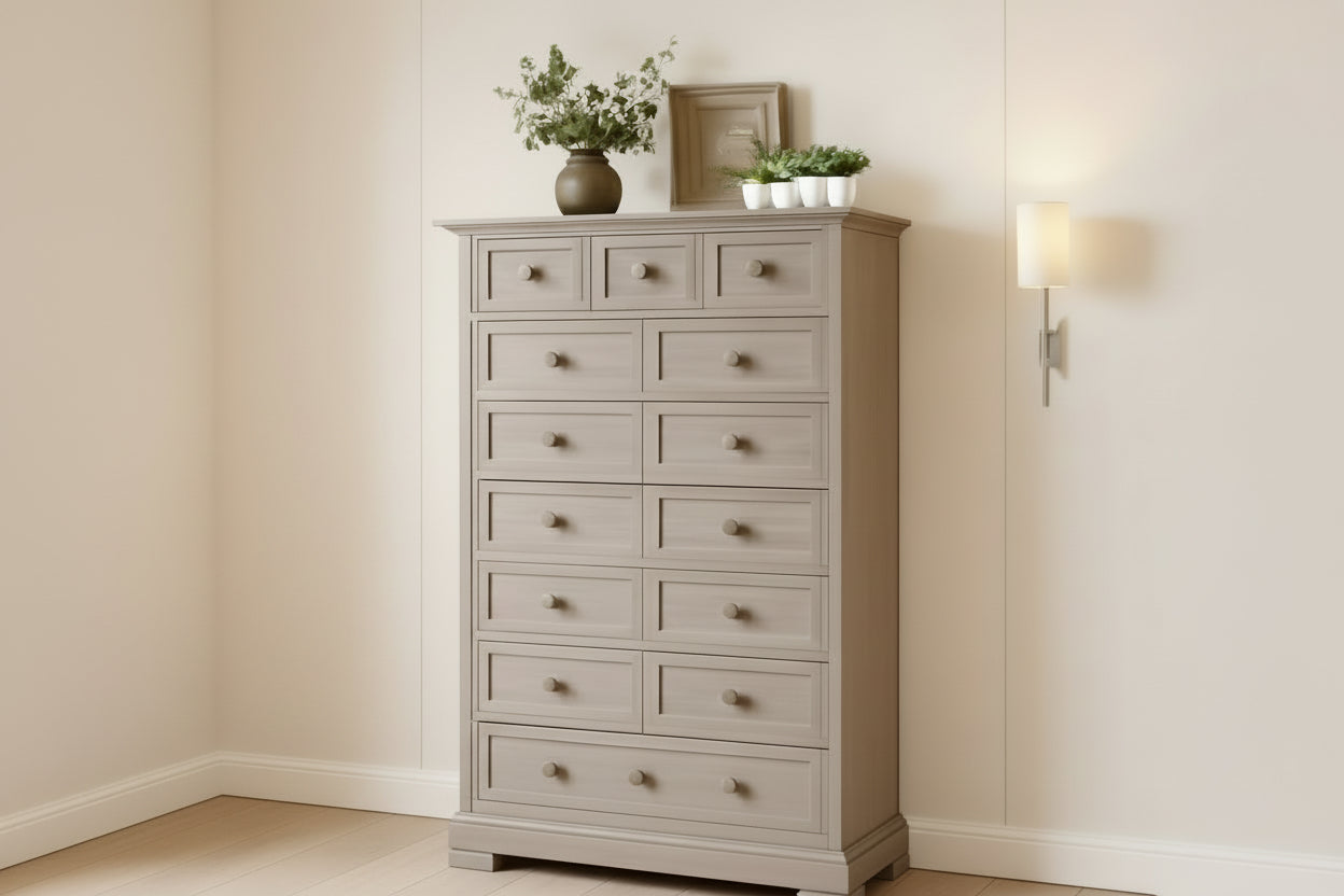Gray dresser with multiple drawers in a room setting with a lamp and decorative items.