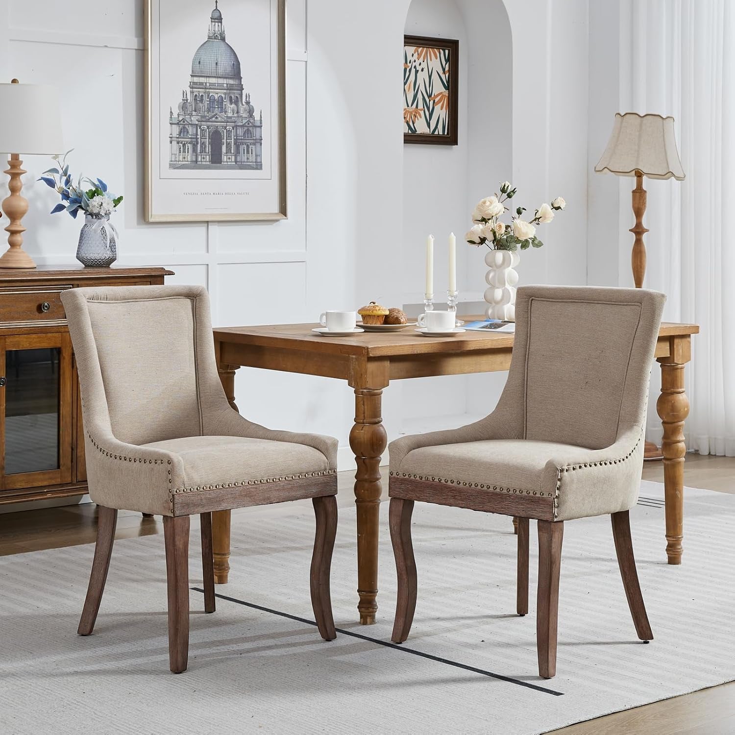 Dining room with wooden table and chairs, framed artwork on the wall.