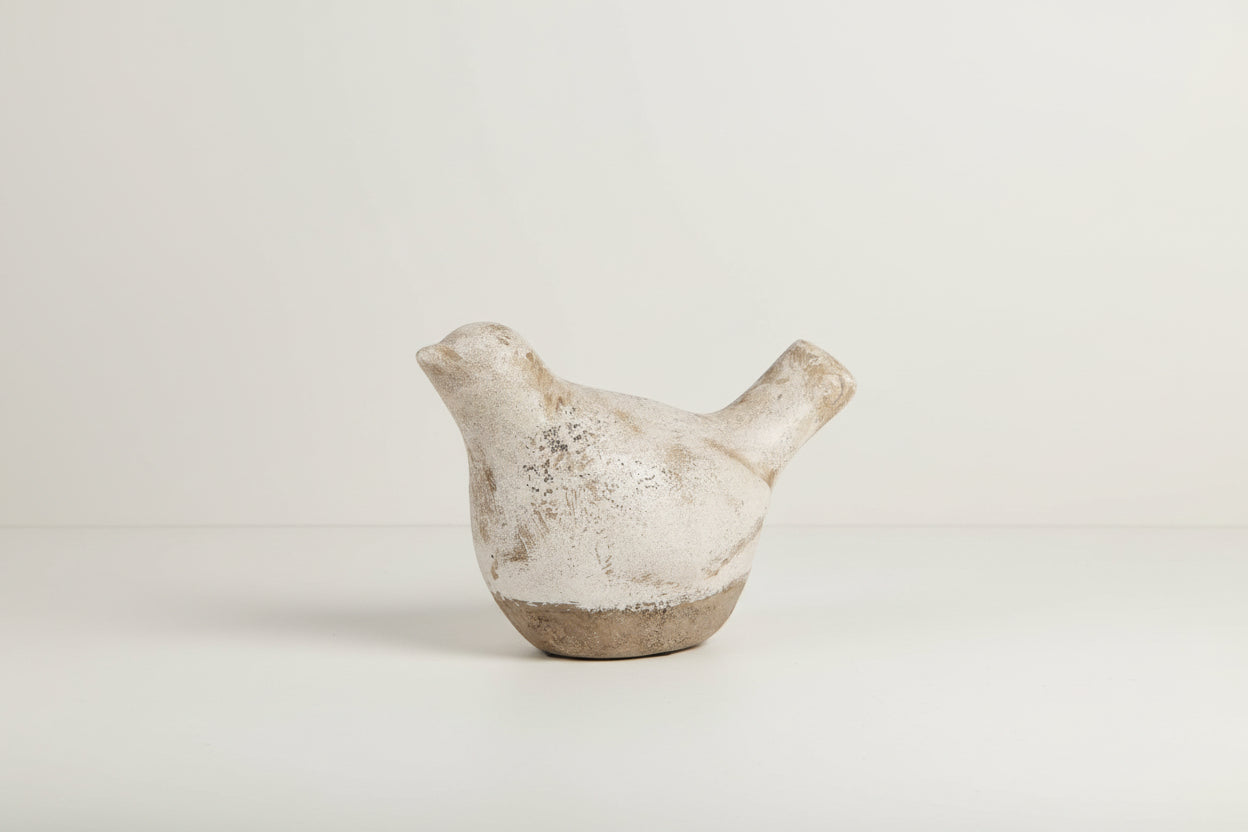 Ceramic bird figurine with a textured surface on a white background