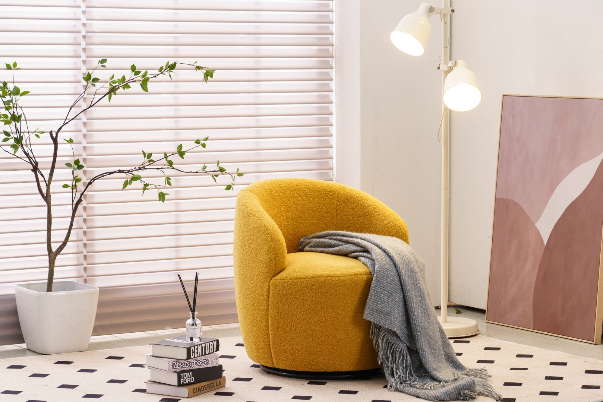 Yellow armchair with a gray blanket in a room with white blinds and a plant.