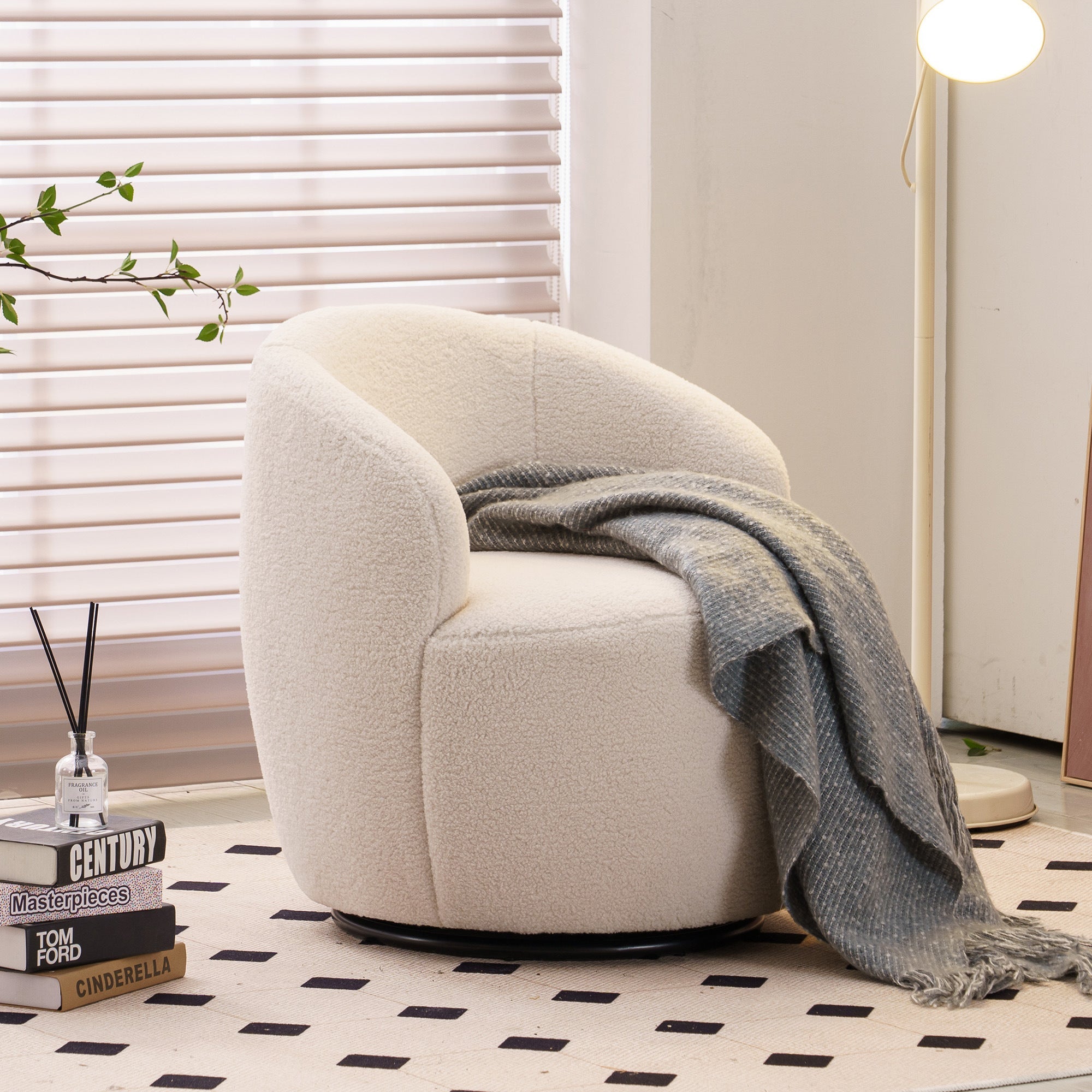 Beige armchair with a gray blanket in a room with white blinds and a black and white checkered floor.