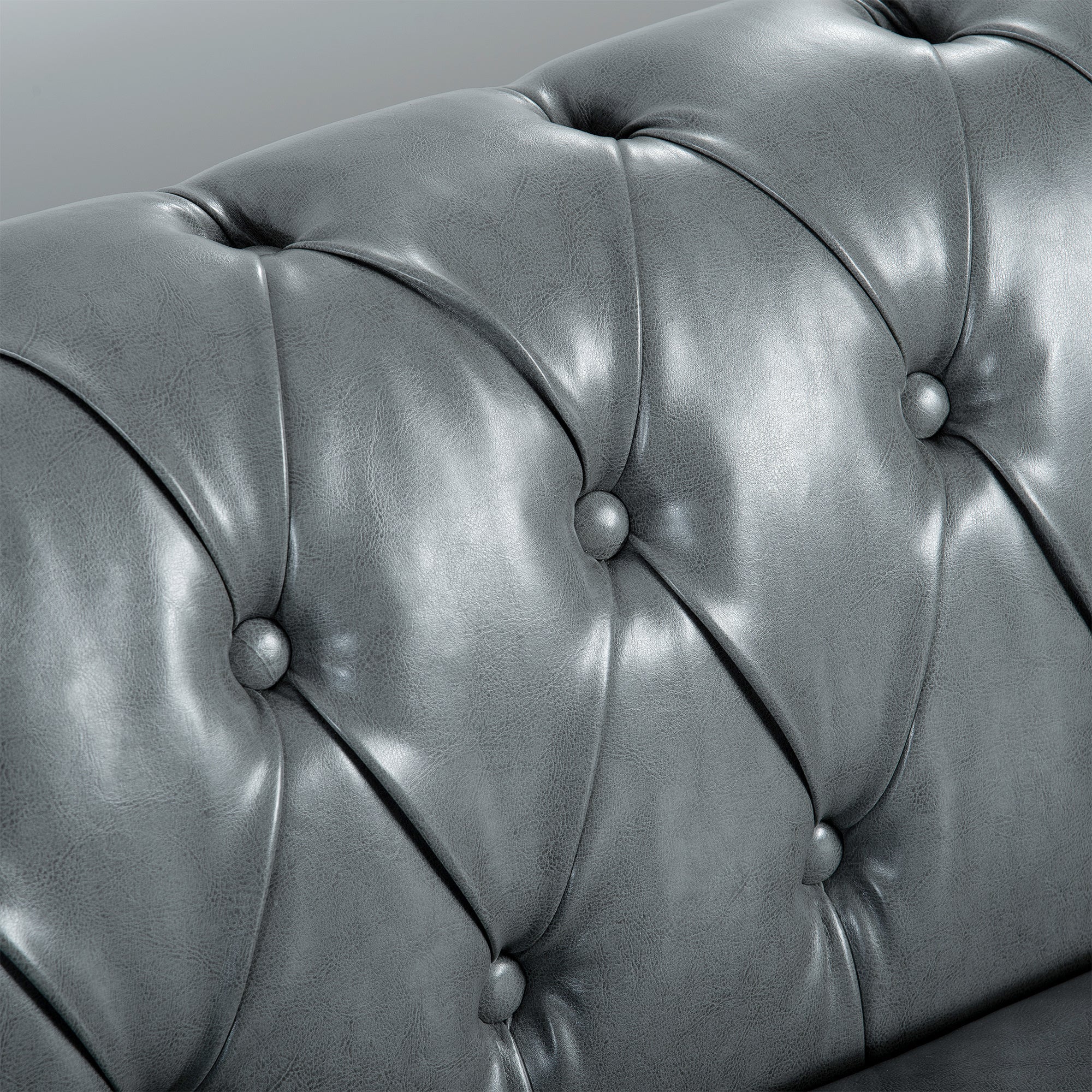 Close-up of a gray tufted leather sofa