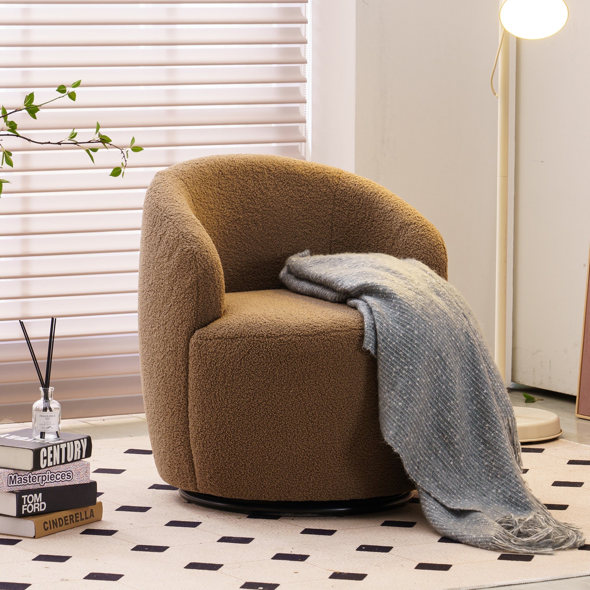Brown armchair with a gray blanket in a room with white walls and a black and white checkered floor.
