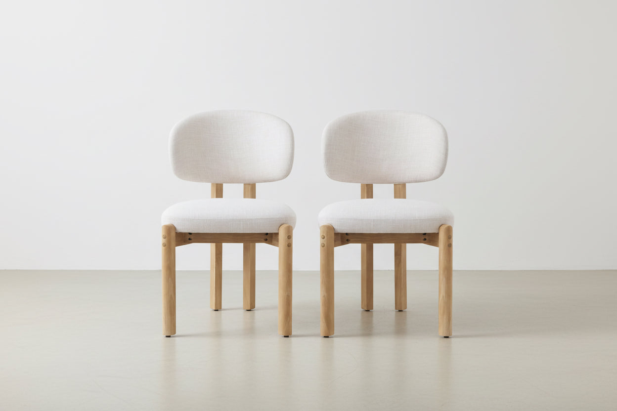 Two beige cushioned chairs with wooden legs on a white background