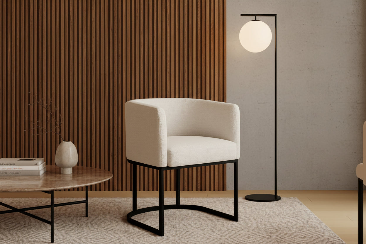 White chair with black metal legs in a room with a beige wall and wooden side table.