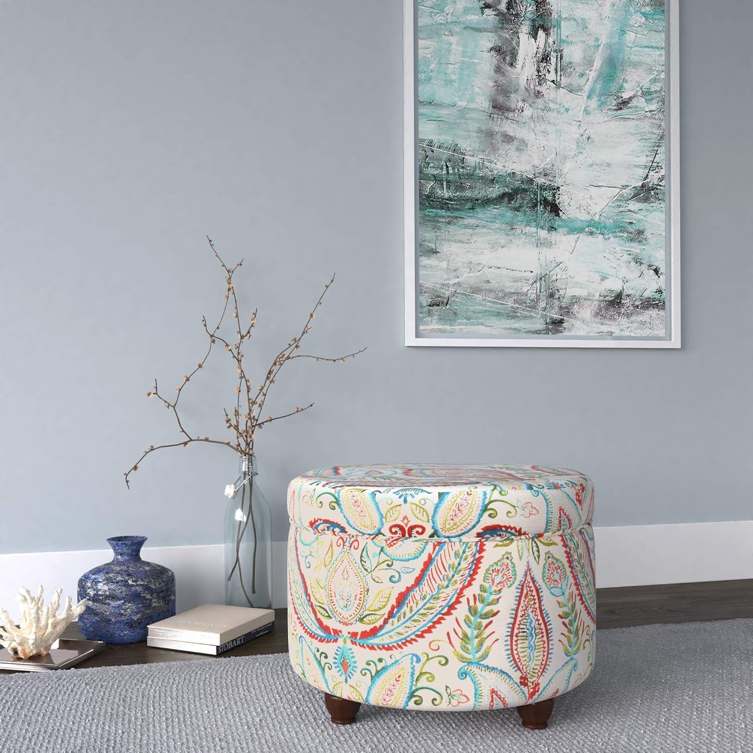 Decorative ottoman with paisley pattern in a living room setting with abstract art on the wall.