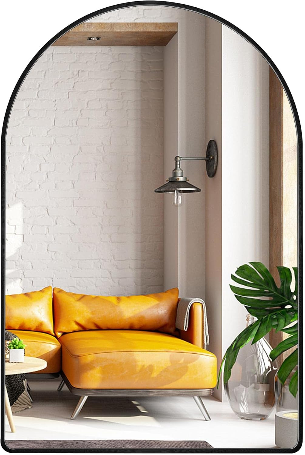 Yellow sofa in a room with a white brick wall, wall lamp, and plant.