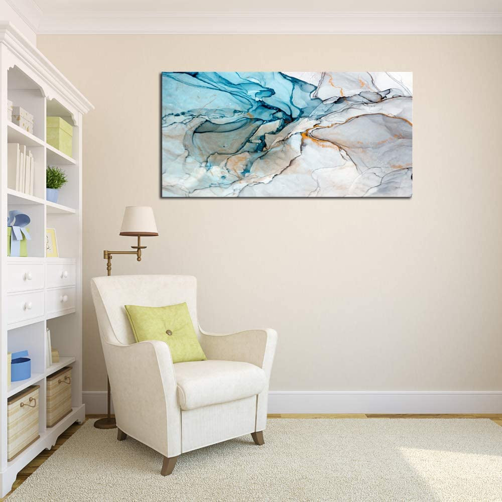 Living room with a white armchair, lamp, and abstract painting on the wall.