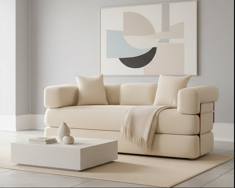 Beige sofa with cushions and a blanket in a room with warm lighting.