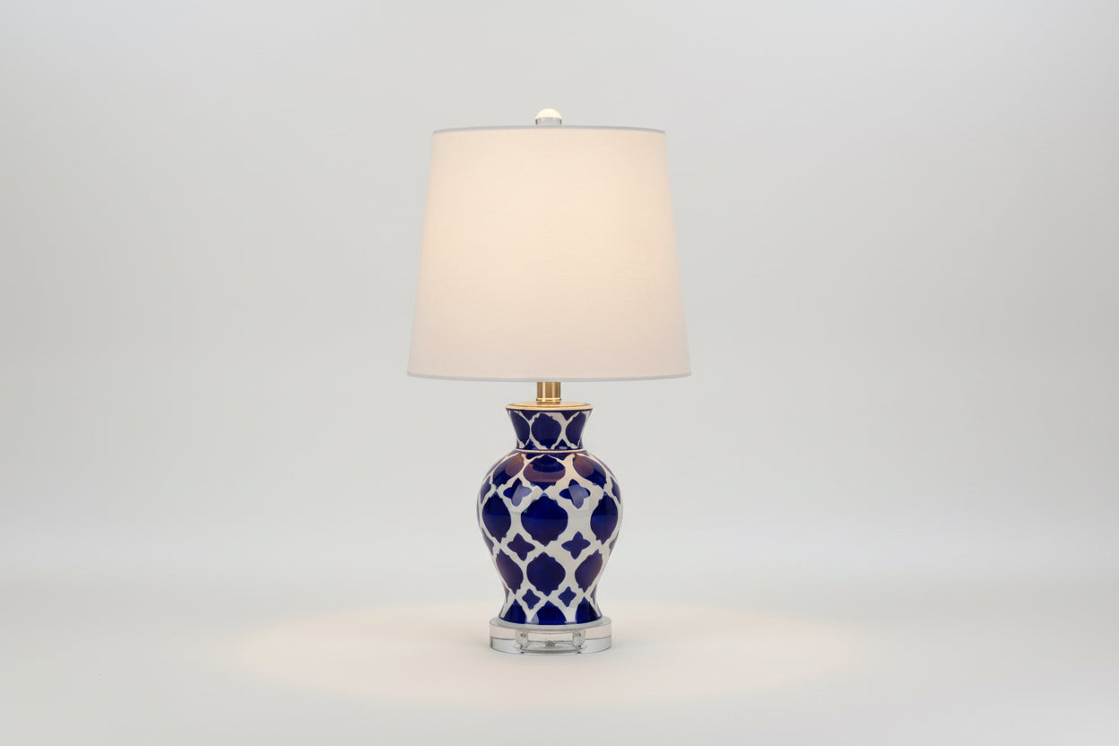 Table lamp with blue and white patterned base and beige lampshade on a white background