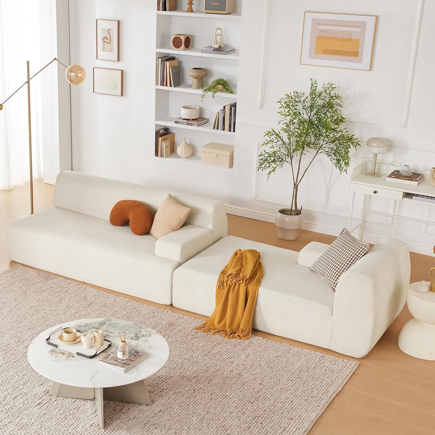 Modern living room with a white sofa, coffee table, and decorative items.