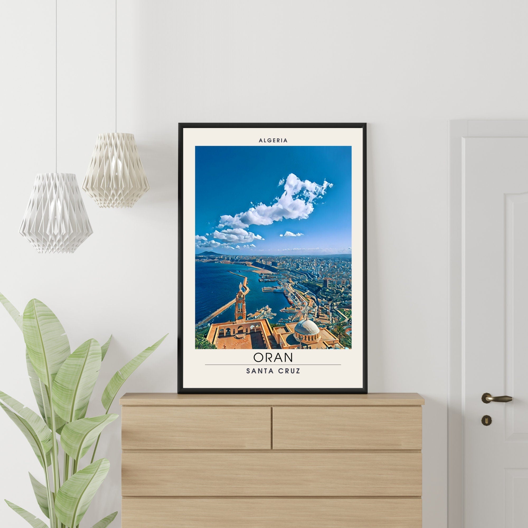Framed poster of Orán, Santa Cruz, Algeria on a wall above a wooden cabinet.