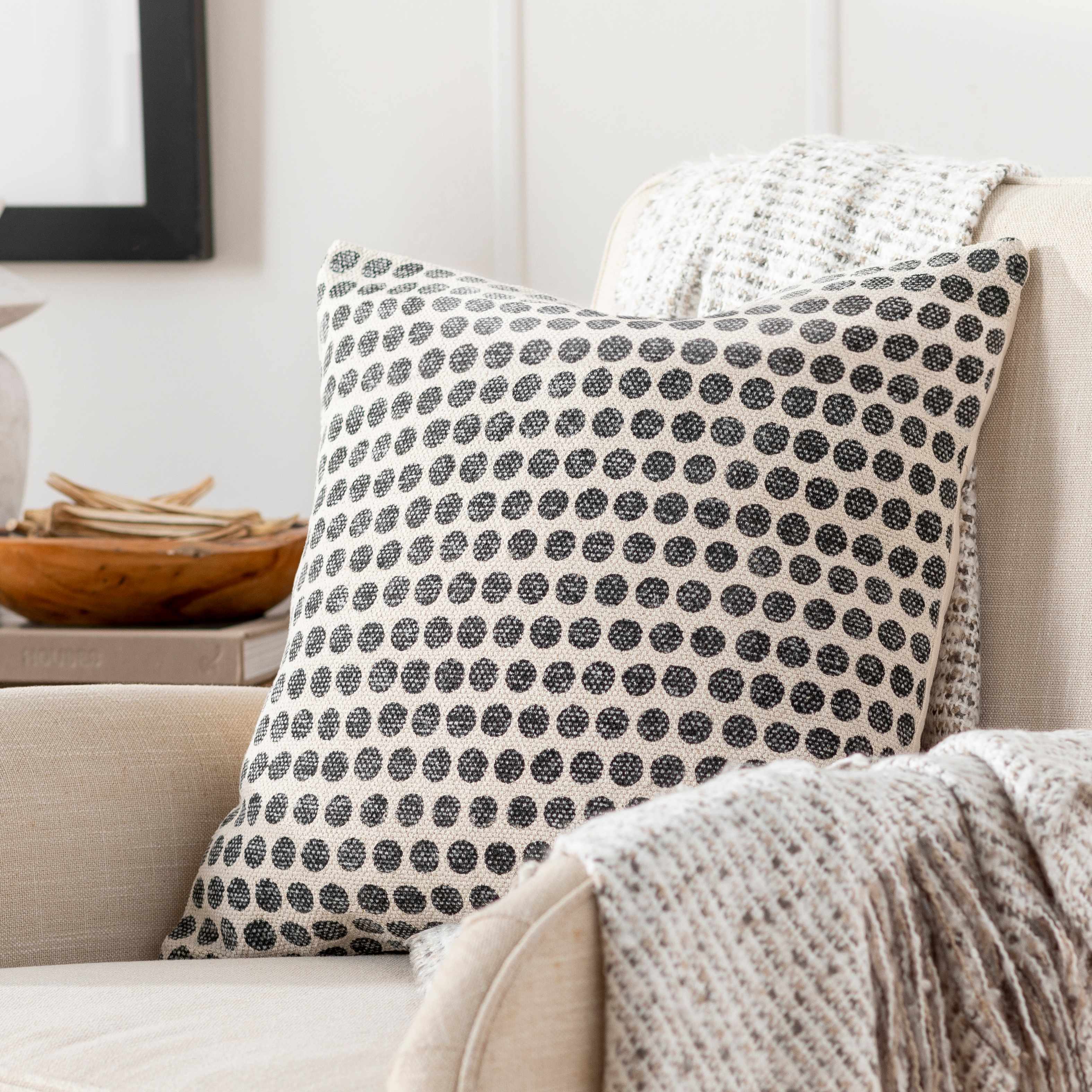 Patterned pillow on a beige sofa with a neutral background