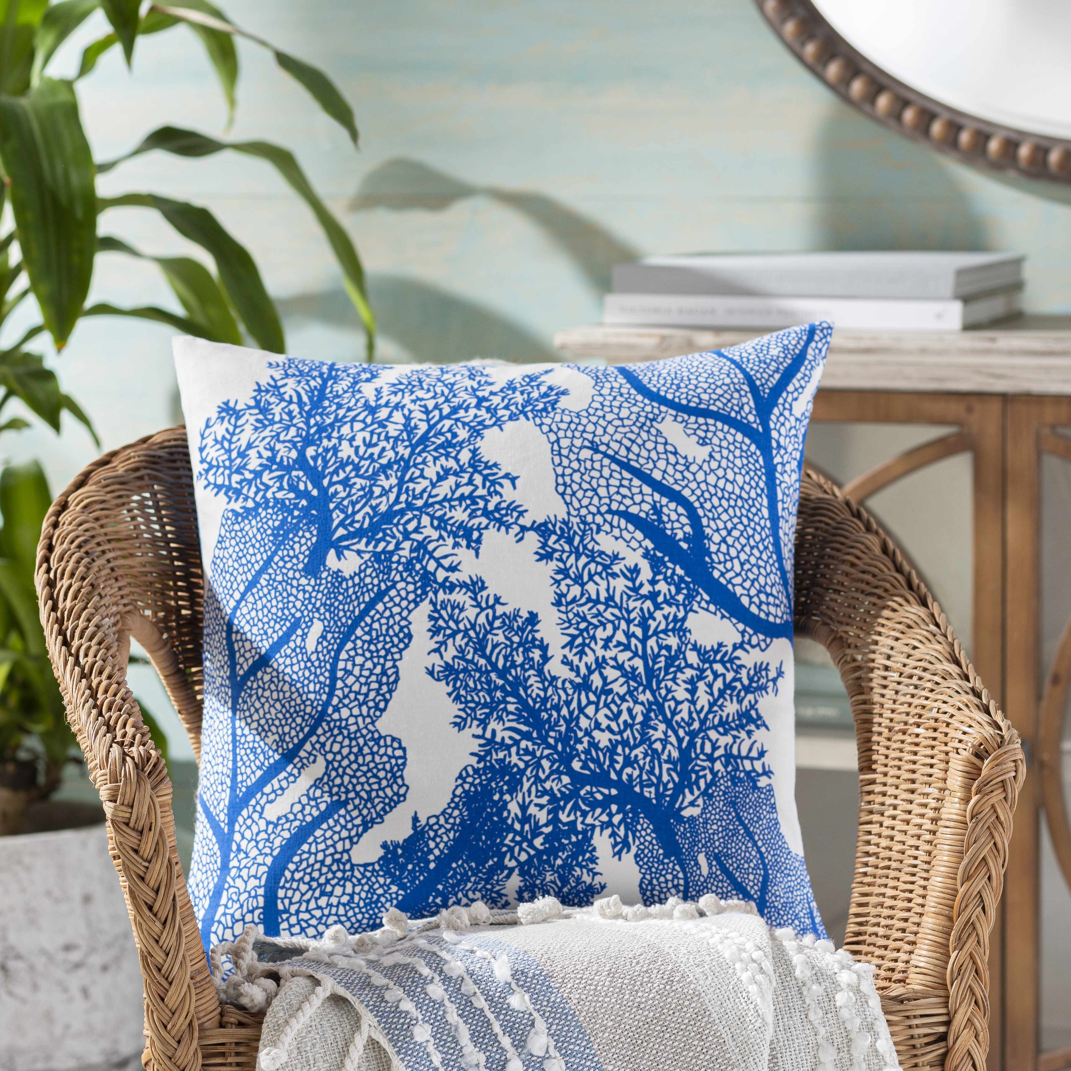Decorative pillow with blue and white pattern on a wicker chair