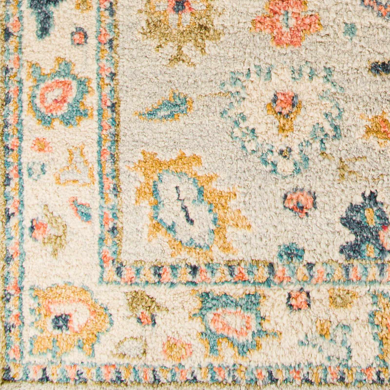 Close-up of a patterned rug with floral designs in multicolors on a beige background.