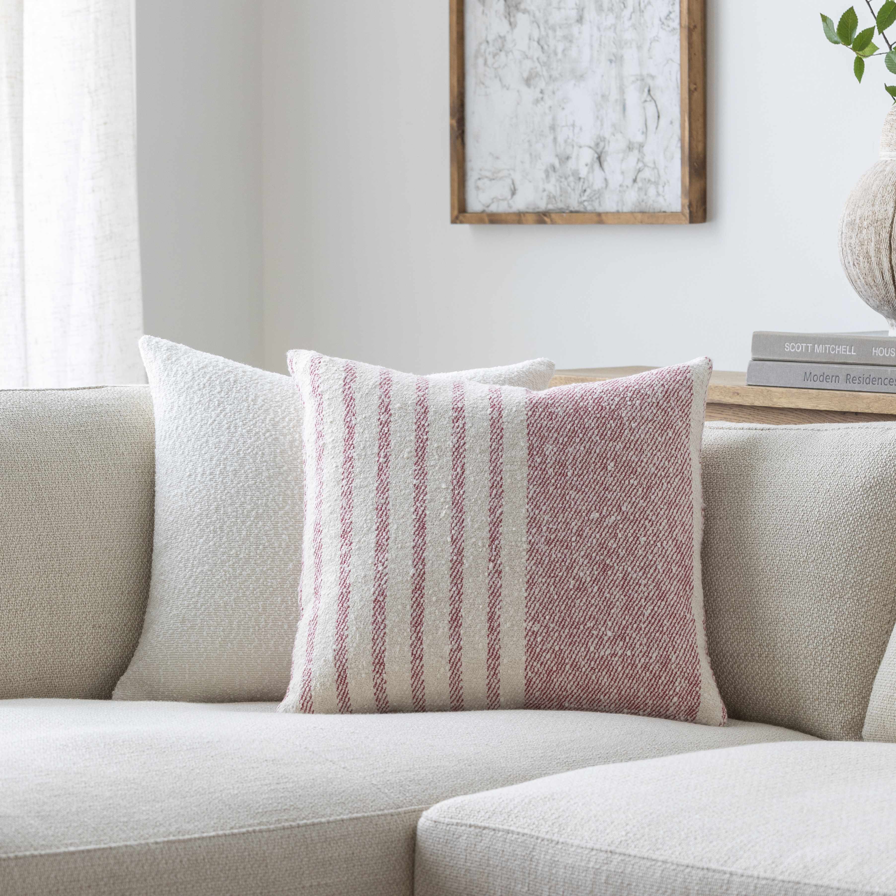 Striped pillow on a beige sofa with a neutral background
