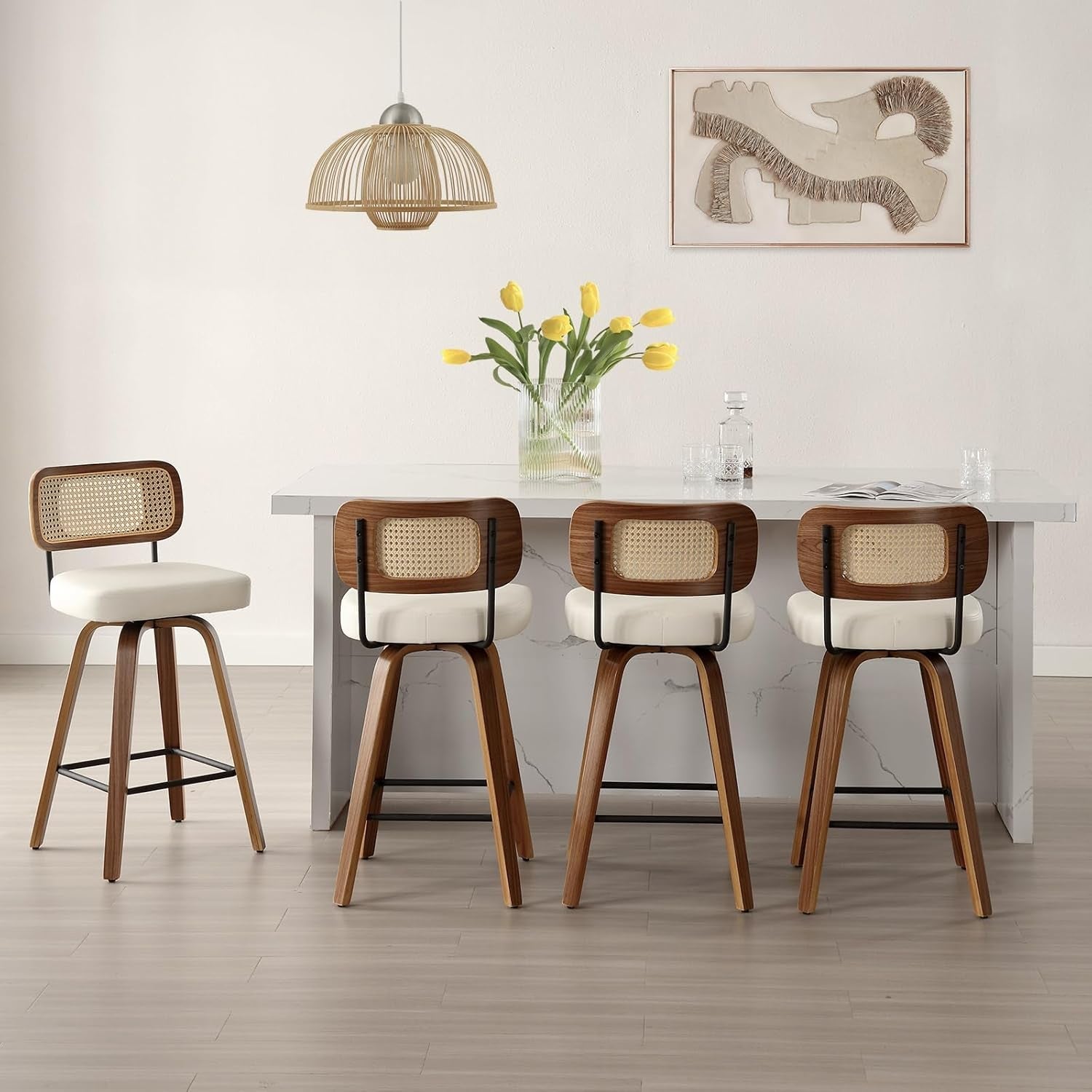 Four wooden bar stools with white seats in front of a dining table with a vase of yellow flowers.