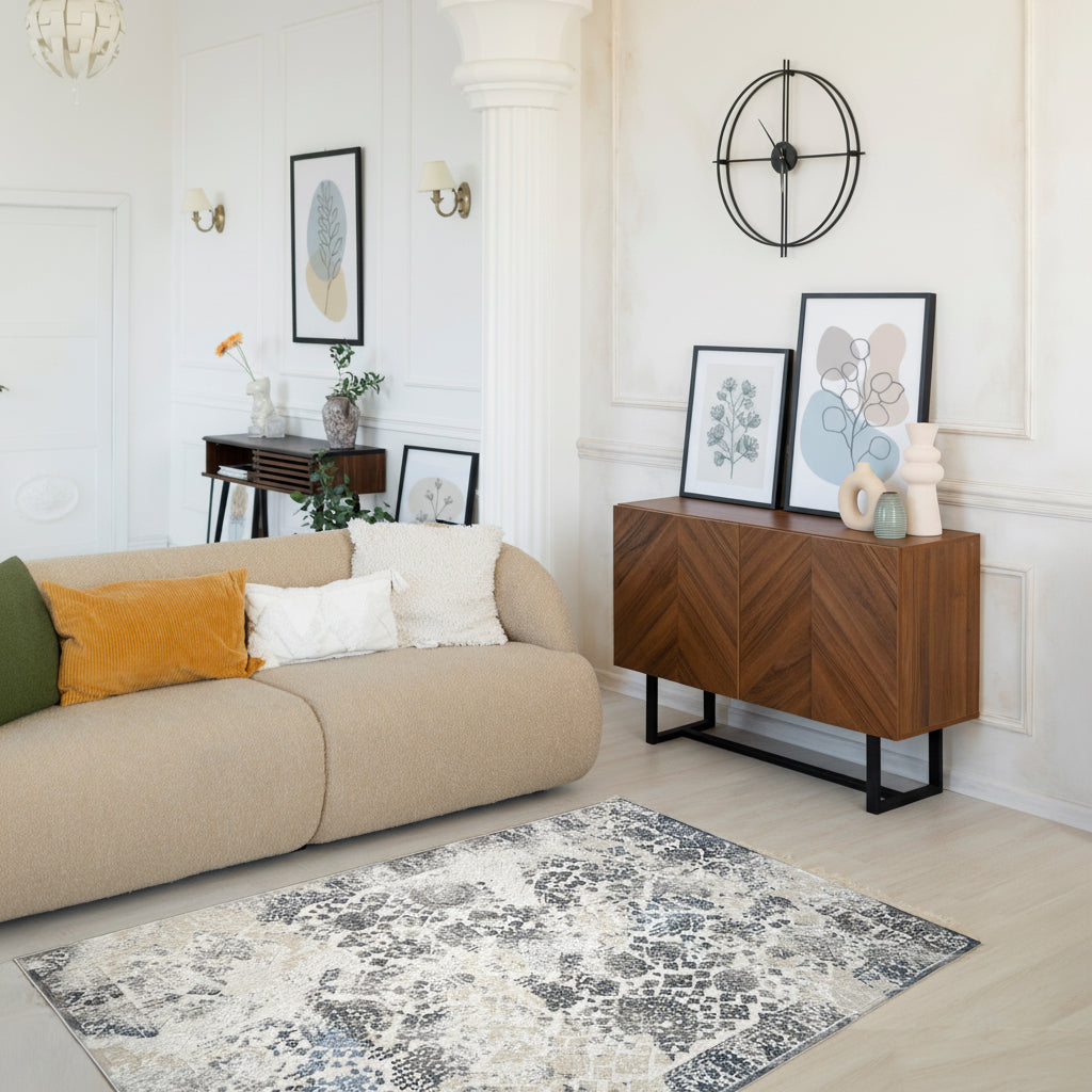 Woman using a laptop in a modern living room with a patterned rug.