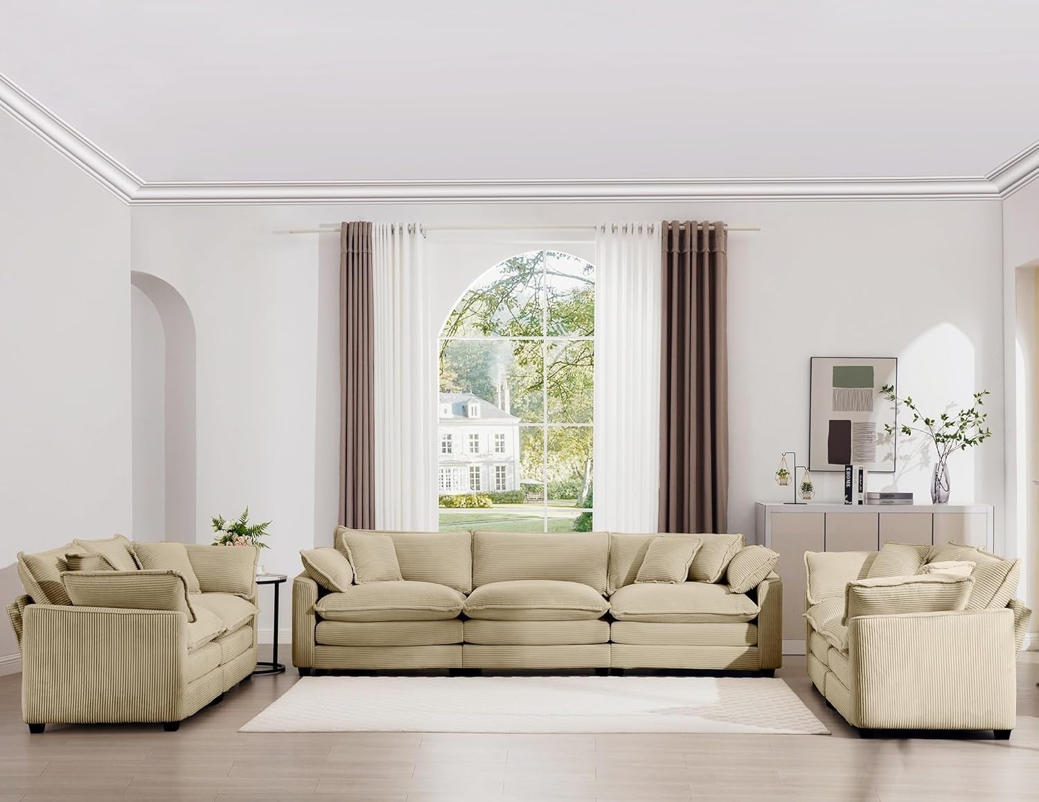 Beige sectional sofa in a modern living room with large windows and neutral decor.