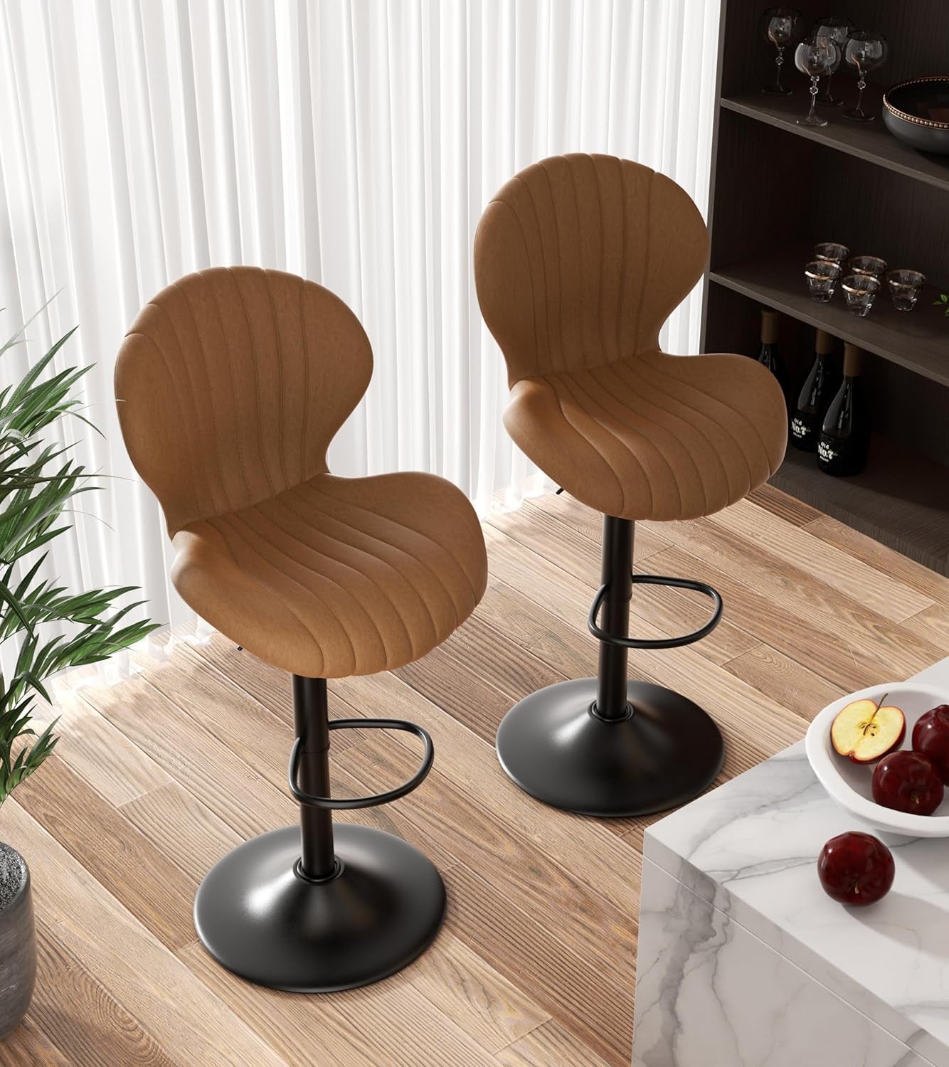 Two brown bar stools with black bases on a wooden floor.