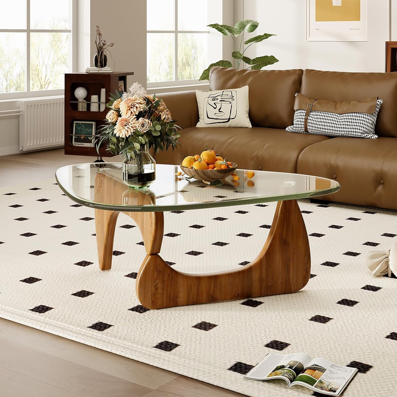Modern living room with a brown sofa, glass coffee table, and decorative elements.