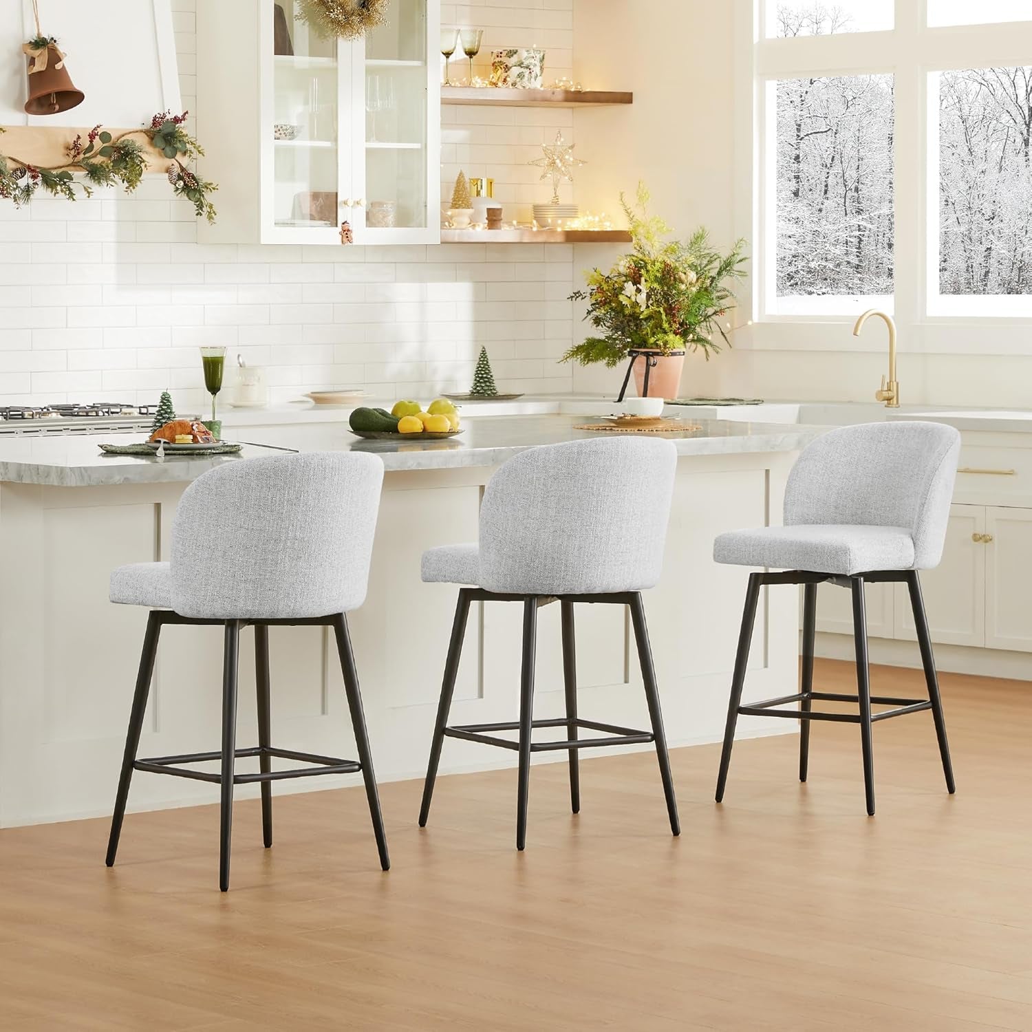 Three gray bar stools with black legs in a kitchen setting.