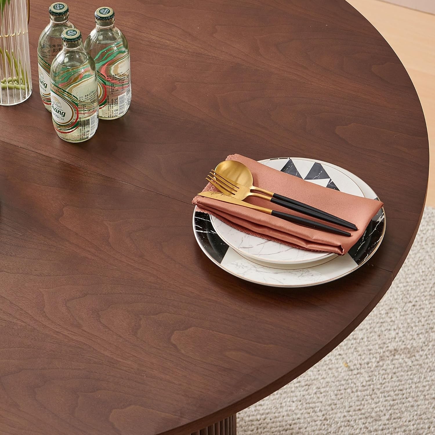 Dining table setting with plates, napkins, and cutlery on a wooden table.