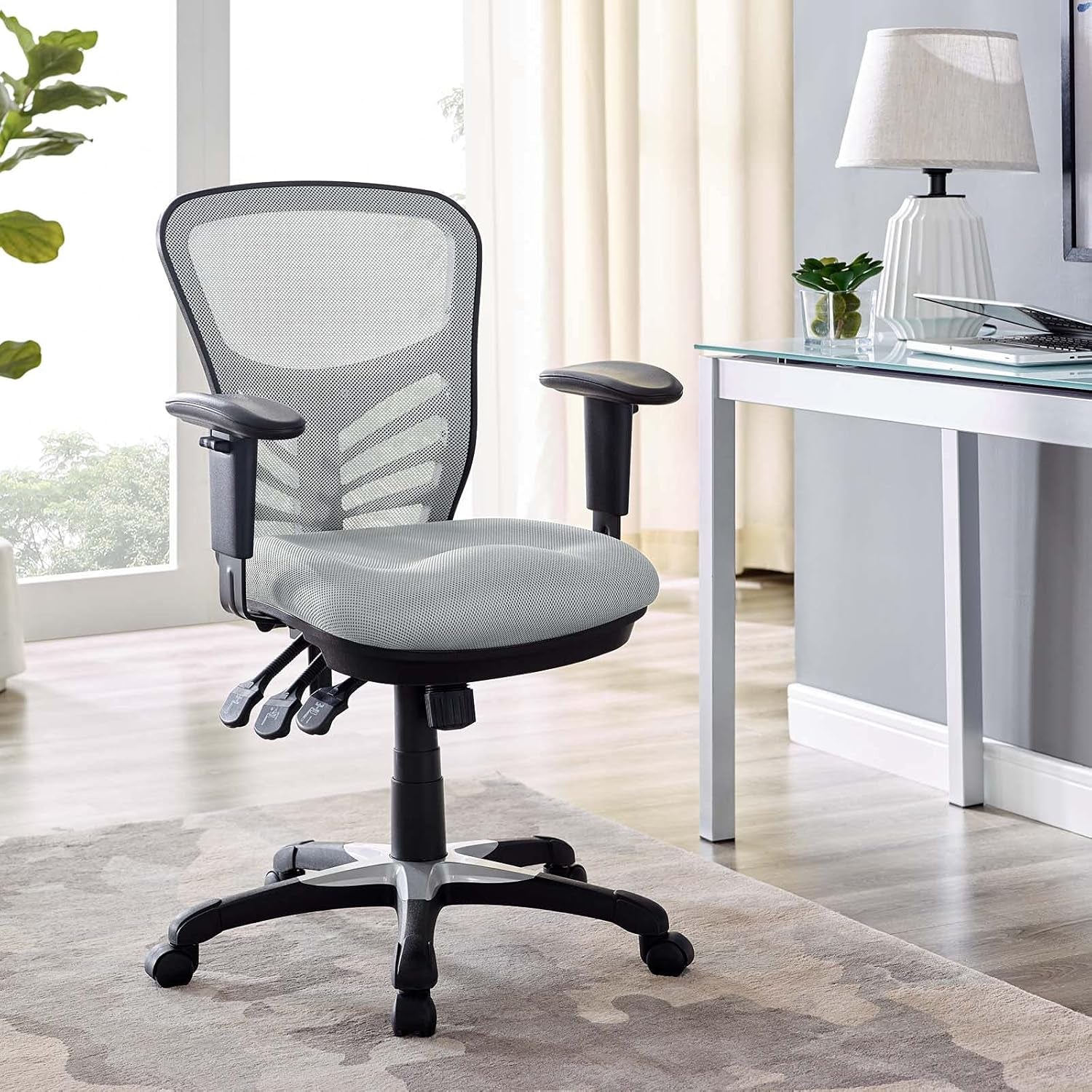 Gray office chair in a home office setting with a desk and lamp.
