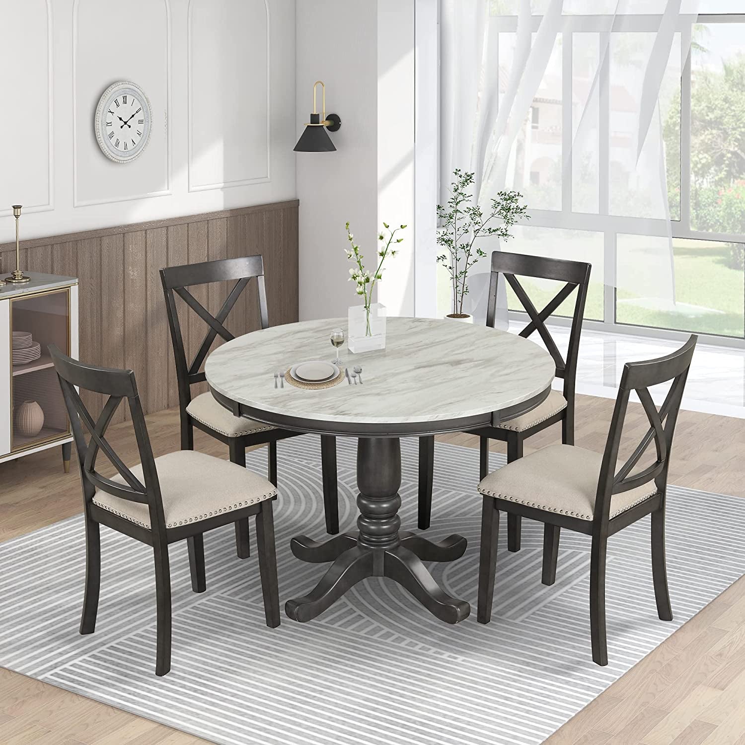 Dining room with a round table and four chairs in a well-lit room.
