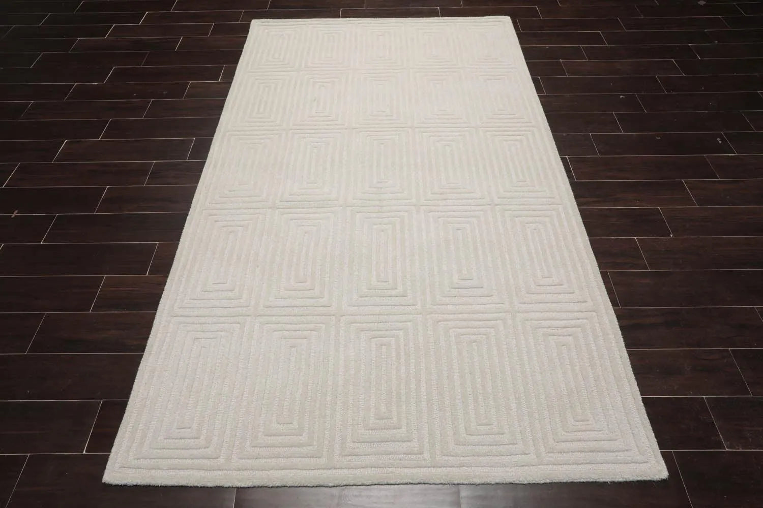 White textured rug on a dark wooden floor