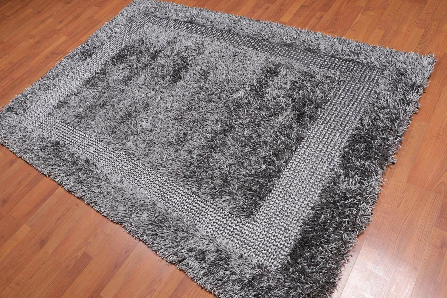 Gray tufted sofa in a modern living room with a gray rug.