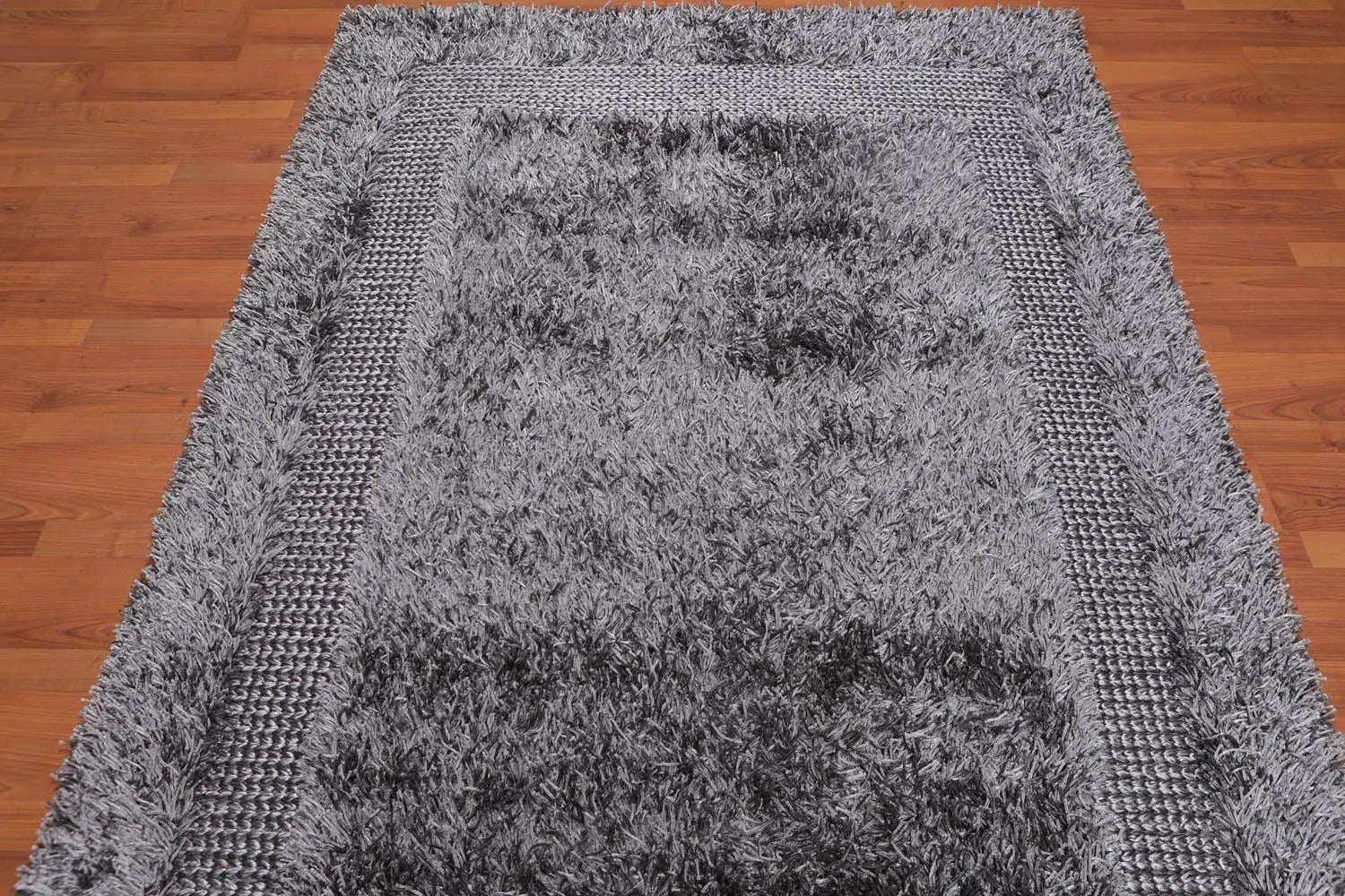 Gray tufted sofa in a modern living room with a gray rug.