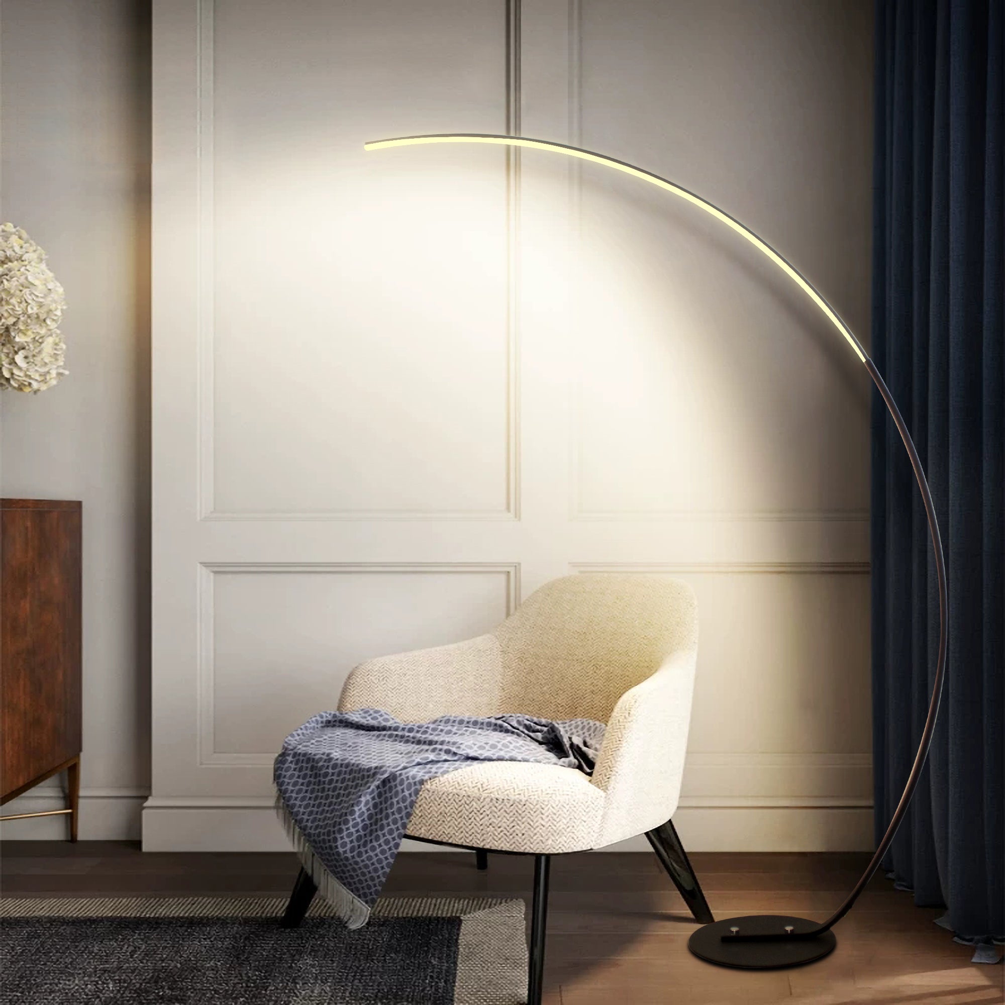 Modern floor lamp casting light on a chair in a room with decorative elements.