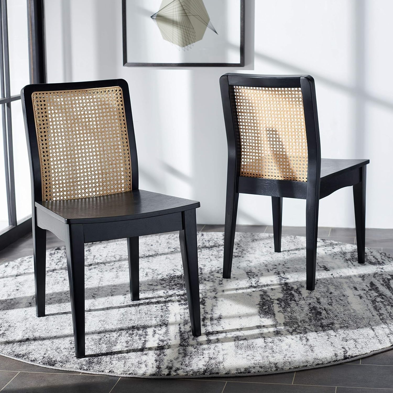 Two black chairs with woven backrests on a patterned rug.