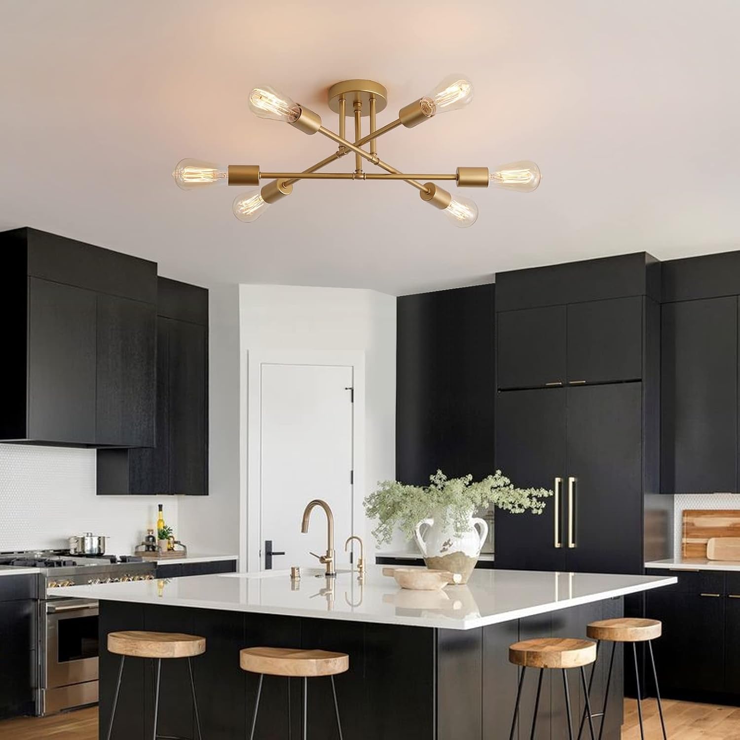 Modern kitchen with black cabinets, white countertops, and a gold ceiling light fixture.