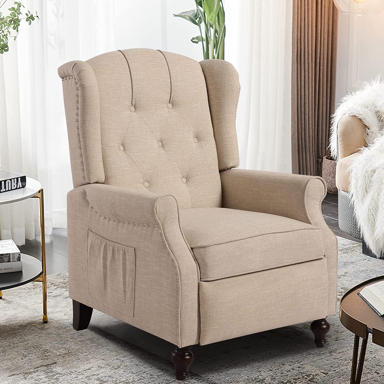Beige armchair in a living room setting with curtains and a side table.