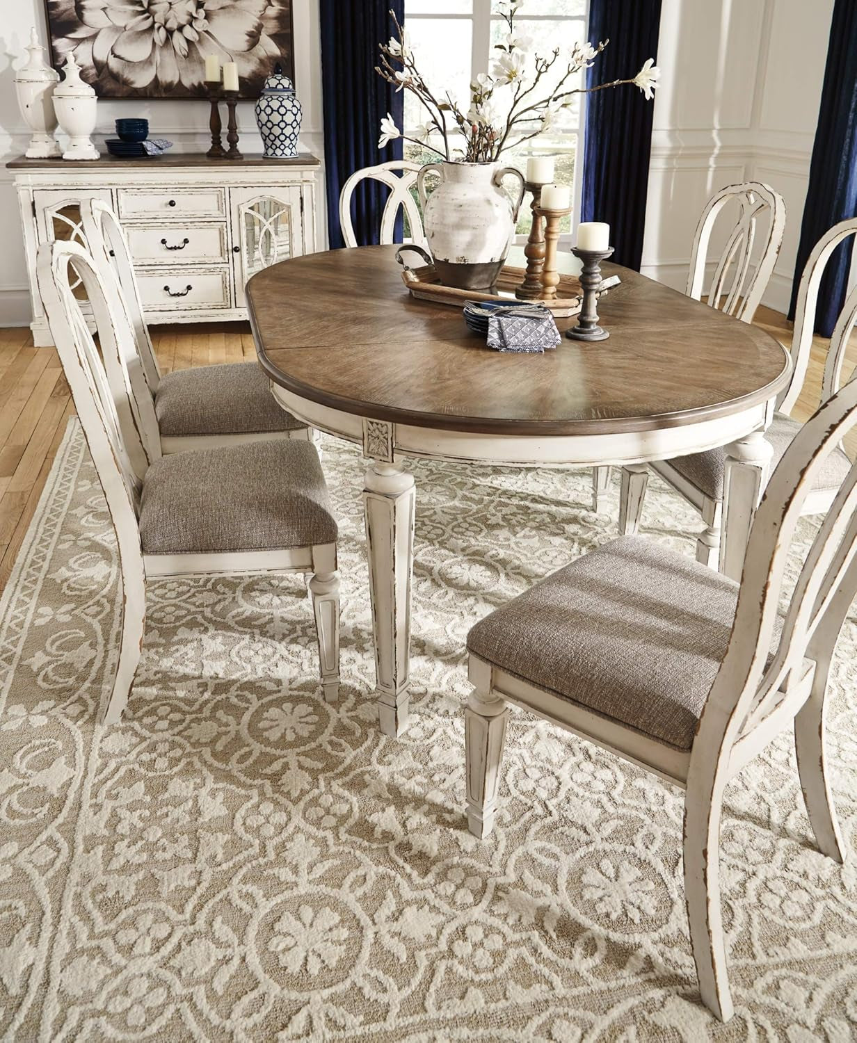 Dining room with a wooden table and chairs on a patterned rug.
