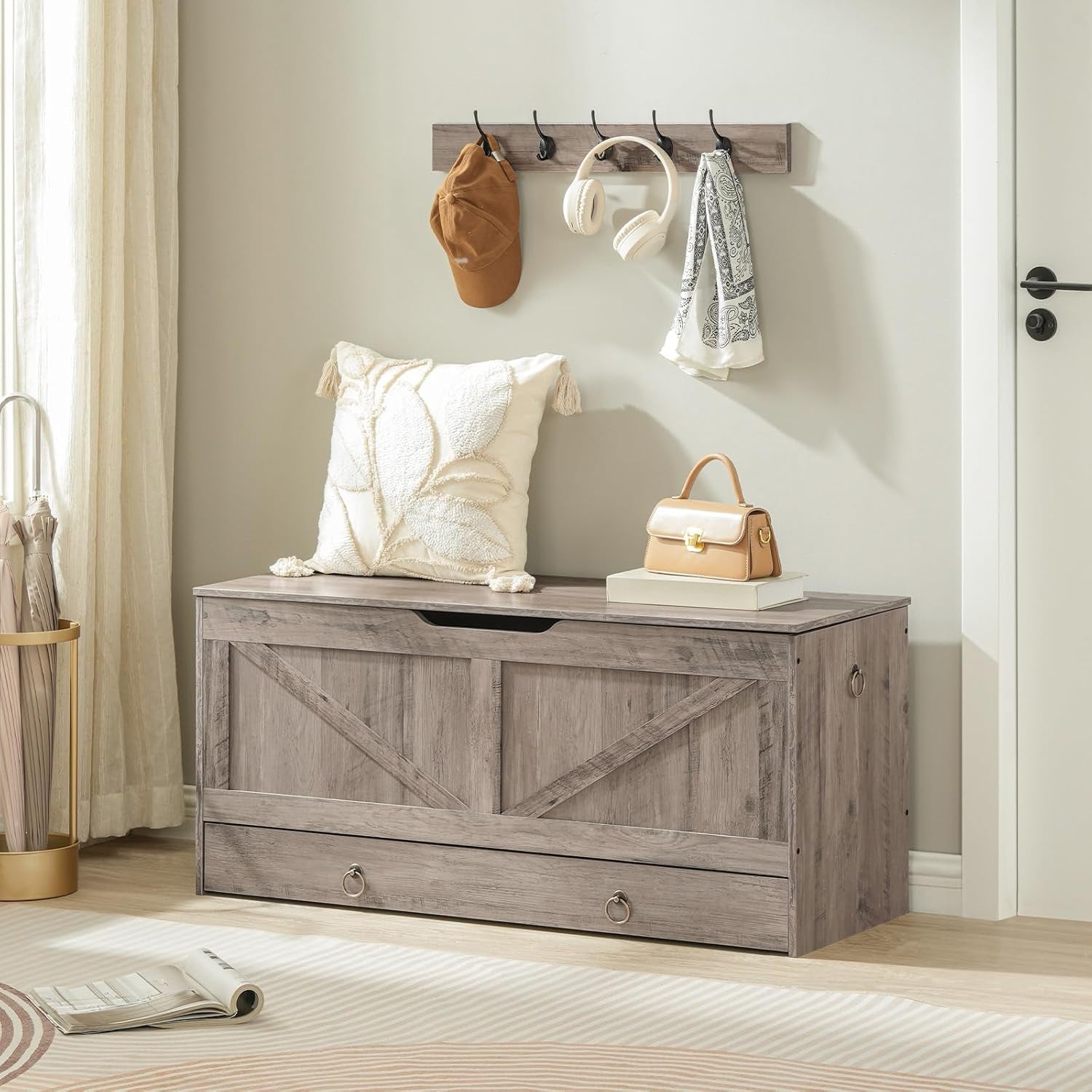 Wooden storage bench with coat hooks and items on a light-colored floor.