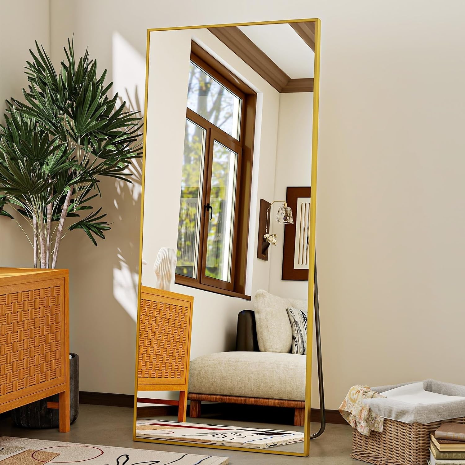 Full-length mirror with wicker frame in a room with a plant and furniture.
