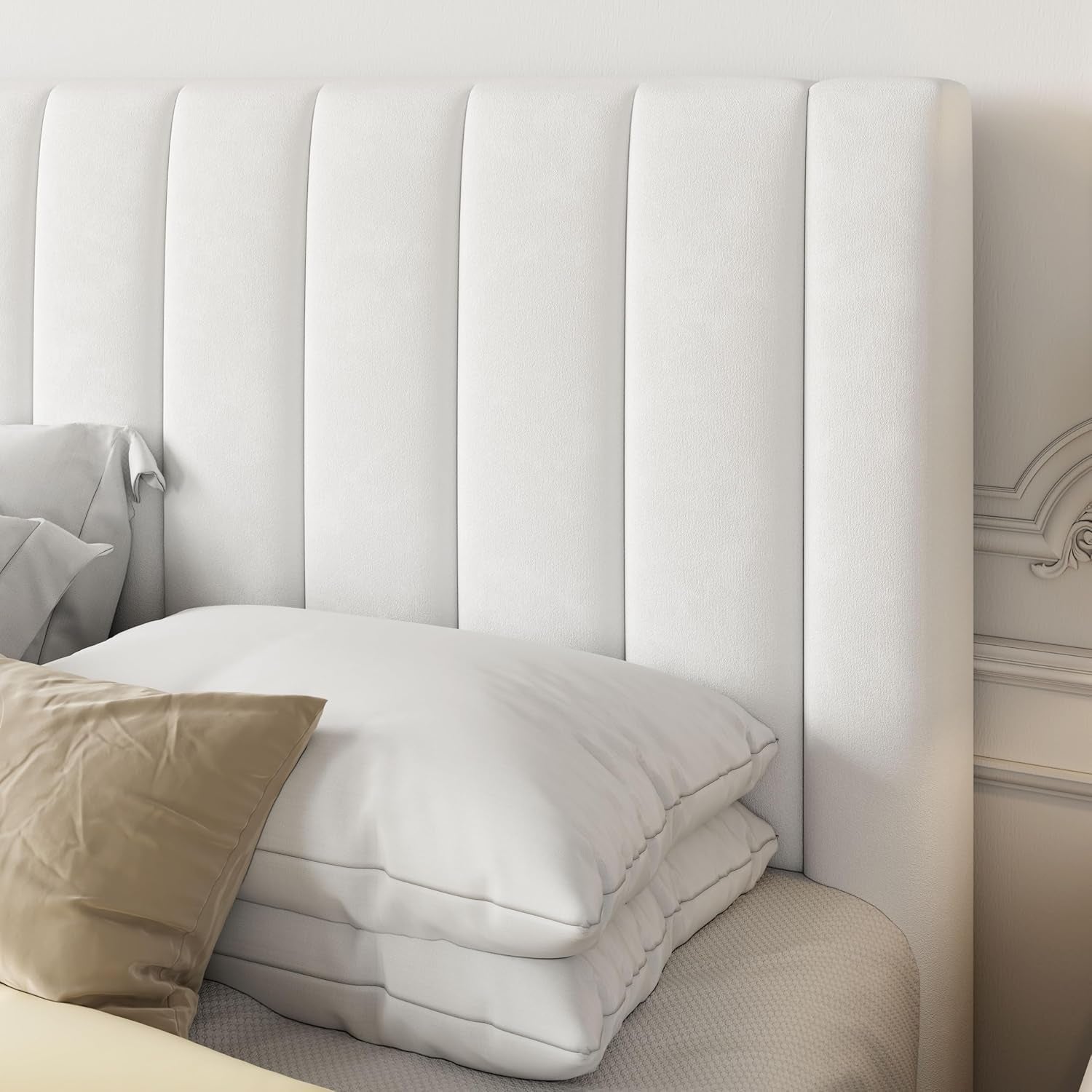 White upholstered headboard with pillows and a beige pillow on a bed.