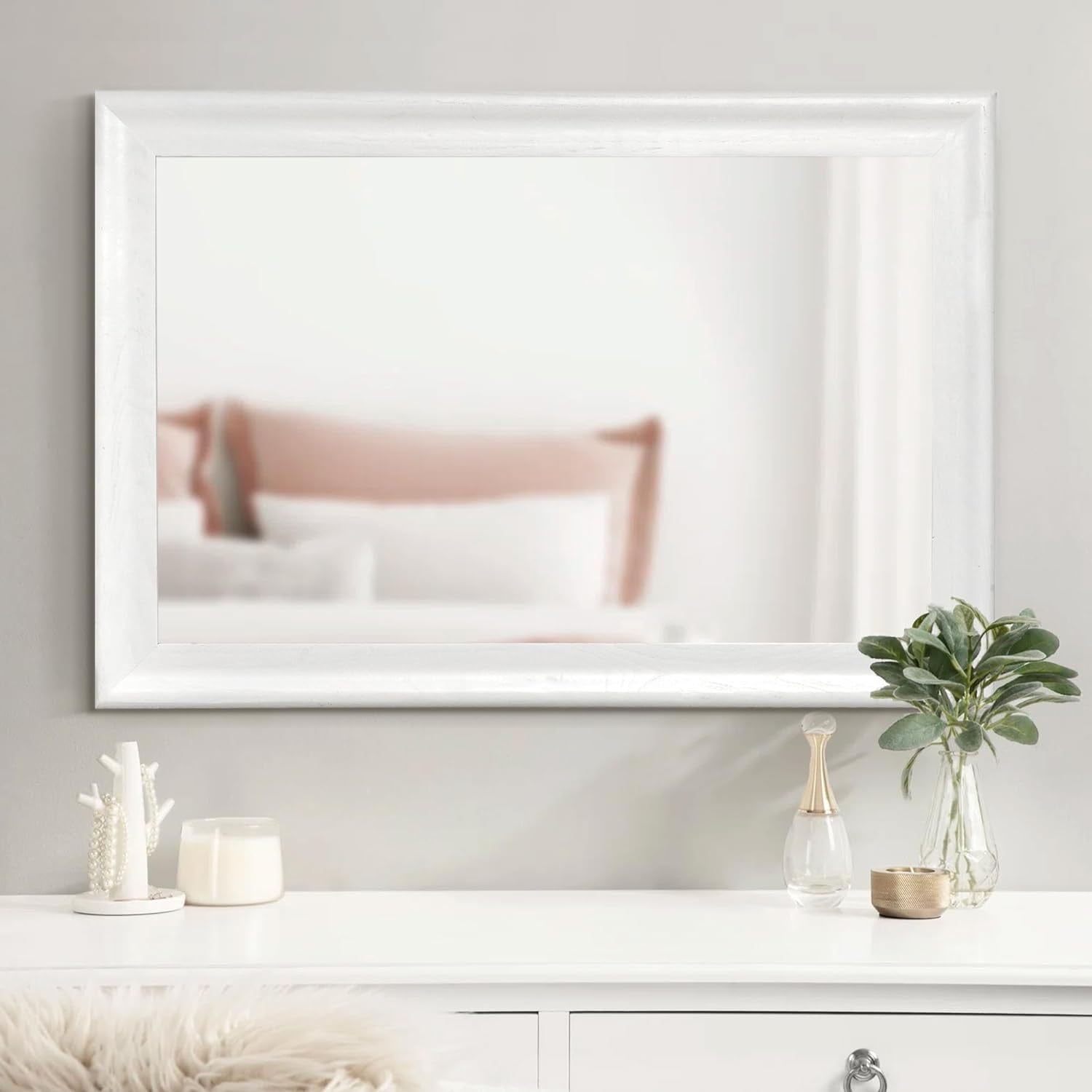 Framed artwork on a wall with decorative items below