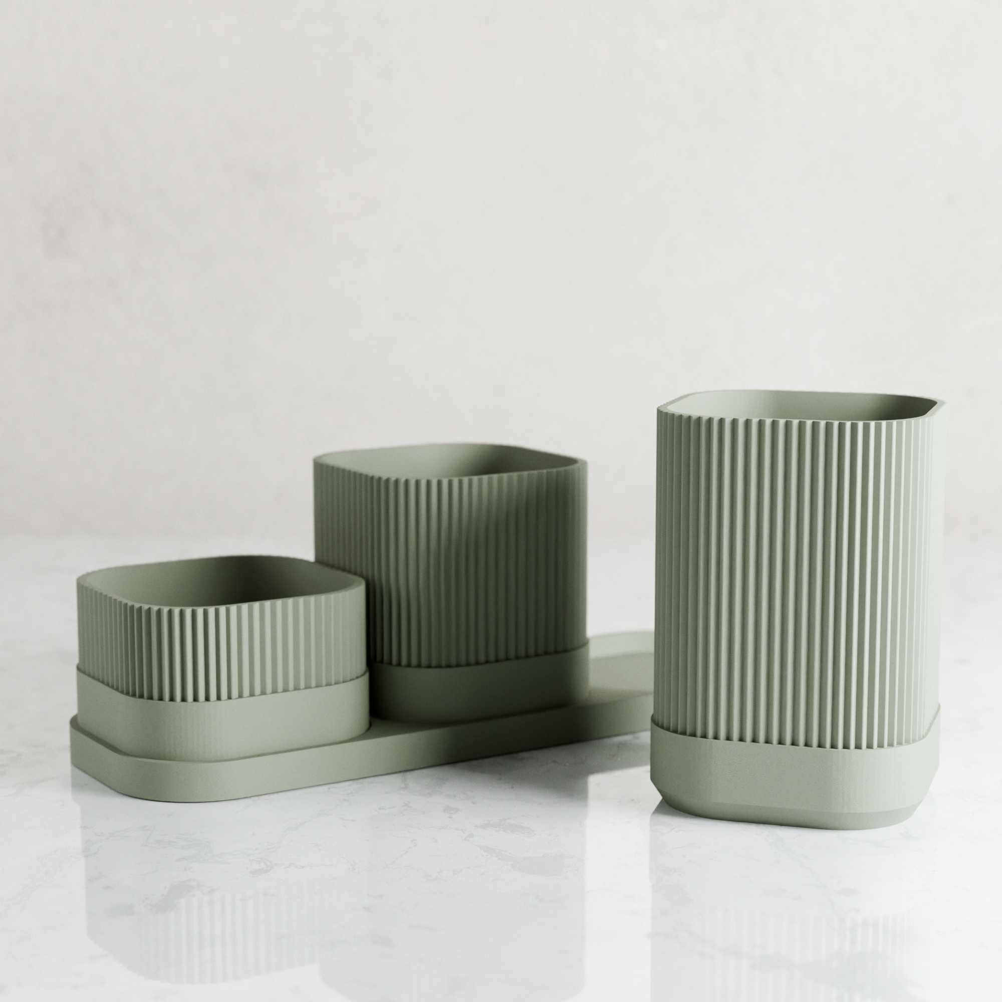 Set of three green textured planters on a light gray background