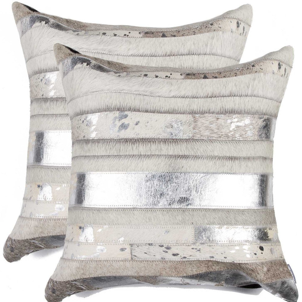 Two decorative pillows with metallic stripe pattern on a white background