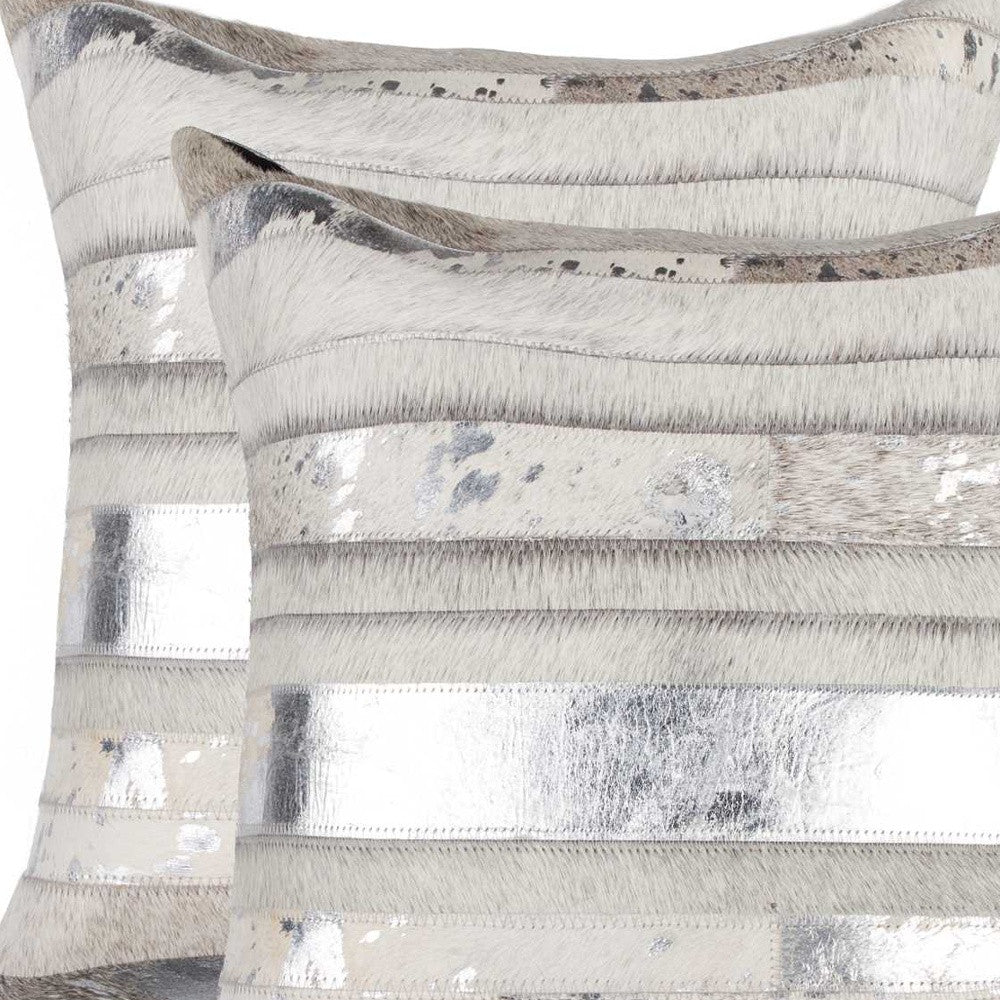 Decorative pillow with metallic strip pattern on a neutral background