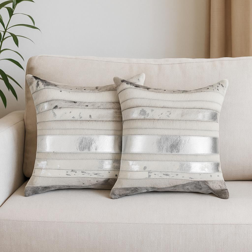 Two decorative pillows with metallic stripe pattern on a beige sofa.