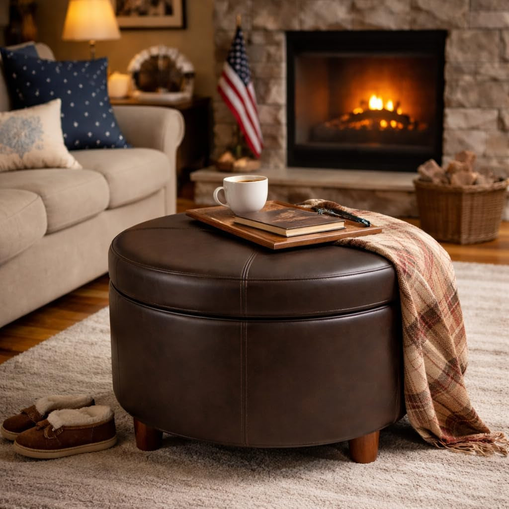 Brown leather ottoman with a cup, books, and a blanket in a cozy living room with a fireplace.