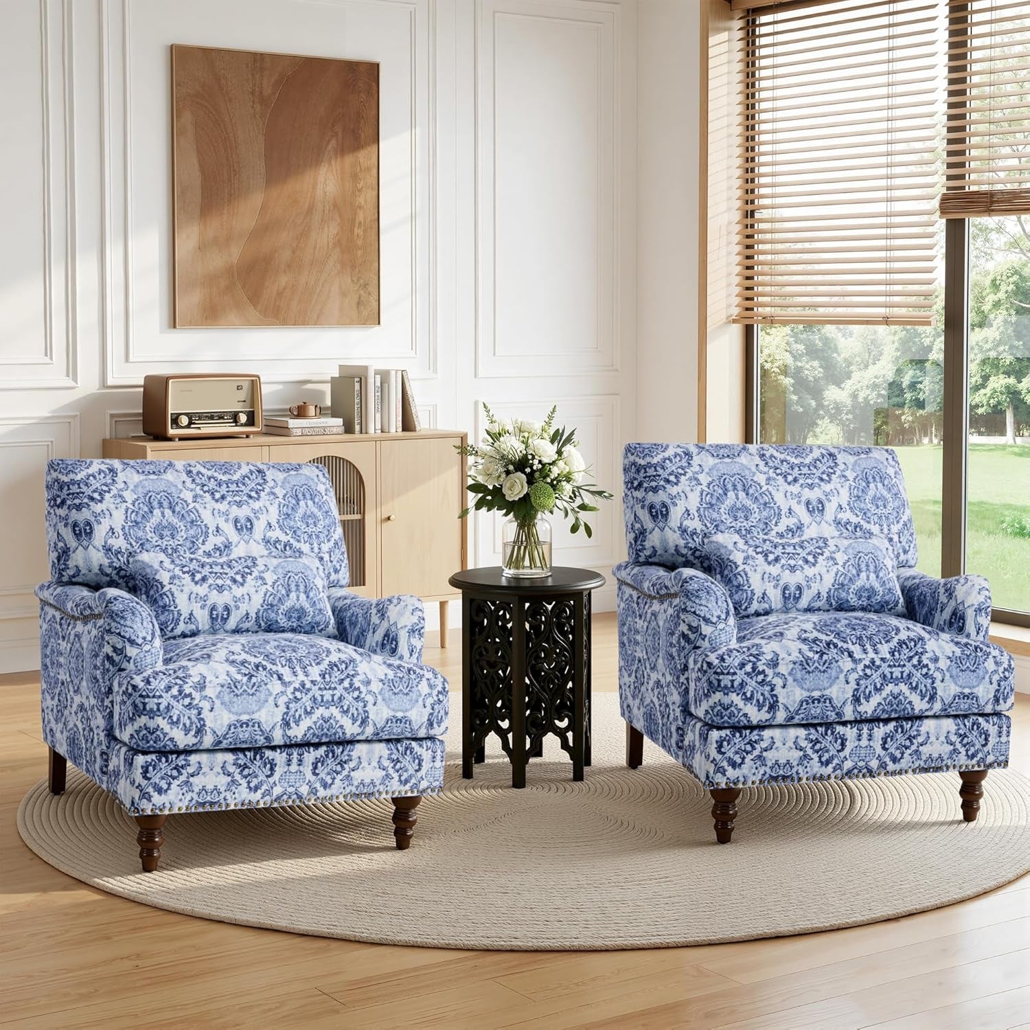 Two blue patterned armchairs in a living room with a side table and window.