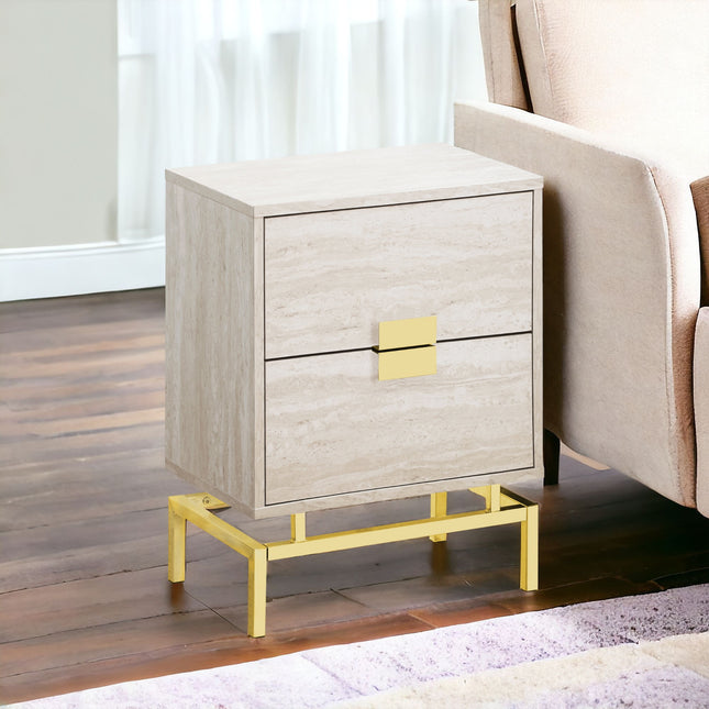 Beige nightstand with gold accents next to a beige armchair in a room.