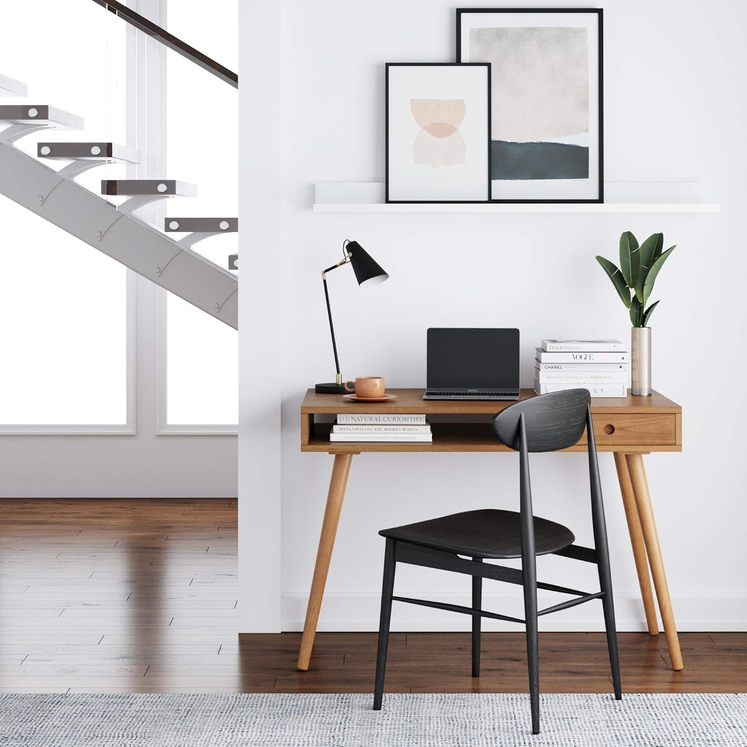 Modern home office with wooden desk, black chair, and decor elements.